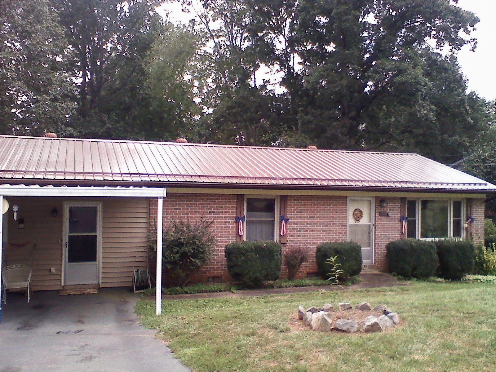 Bronze metal roof and carport on a brick ranch home — Roof Repair work by our crew in Fallston
